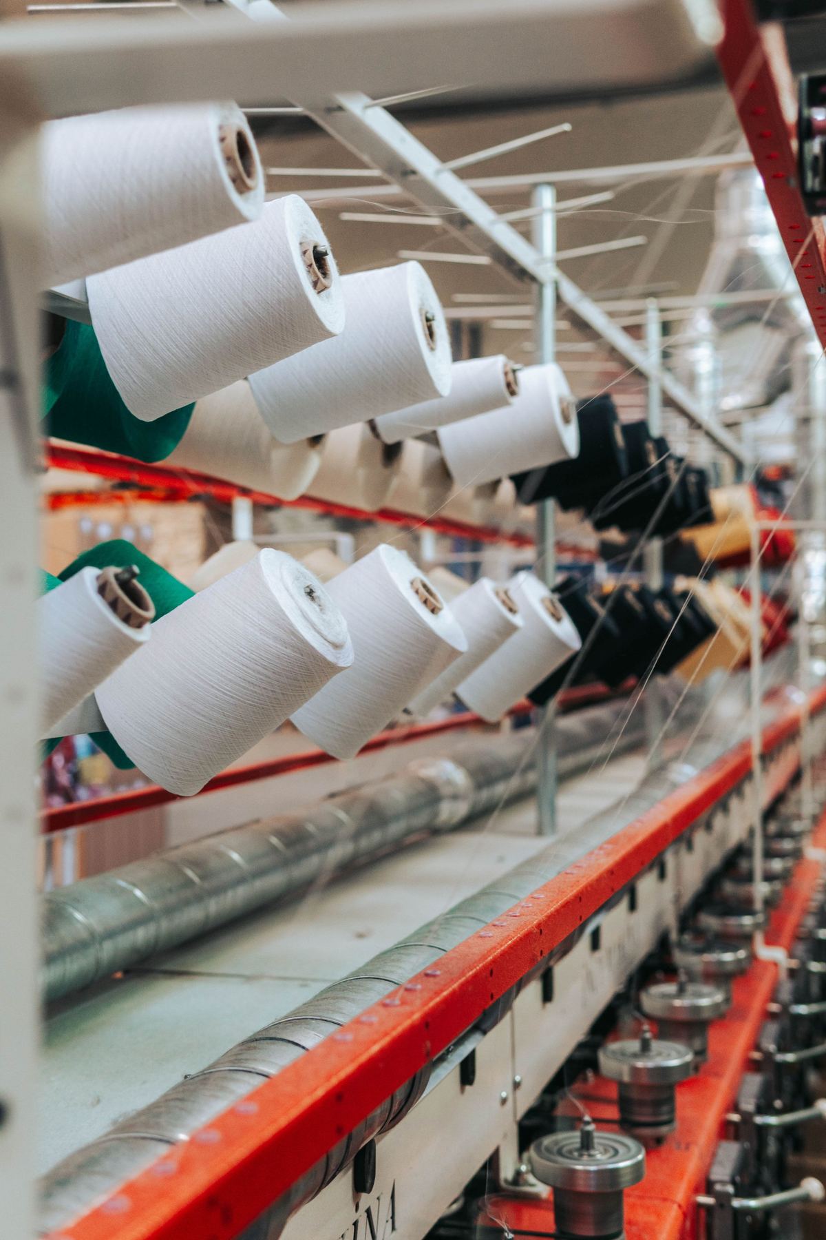Cones of fine yarn feeding into textile machinery in a spinning mill
